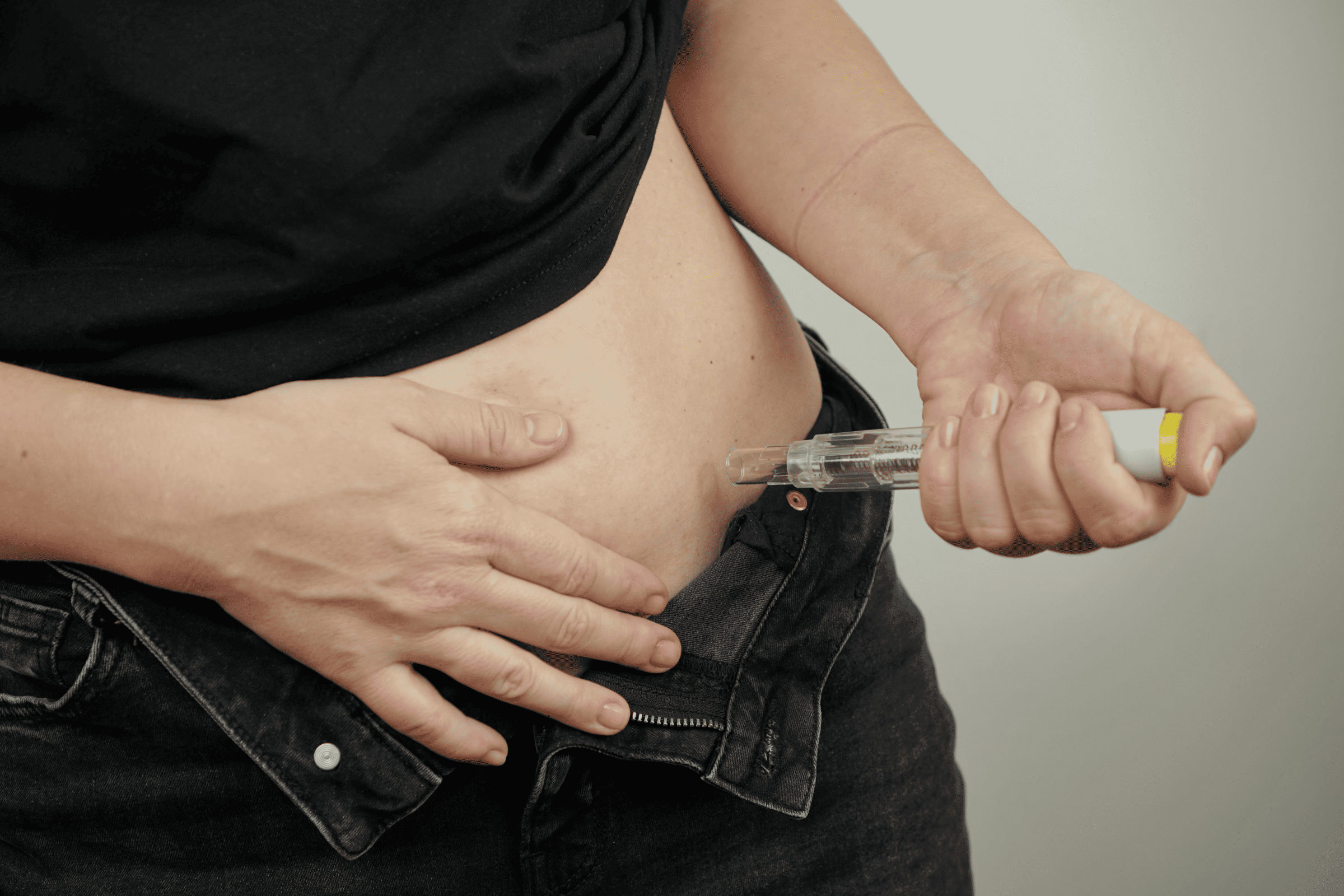 Person injecting Ozempic into their abdomen using a pen injector. Lawsuits claim Ozempic and Wegovy may cause stomach paralysis (gastroparesis) and severe gastrointestinal issues.